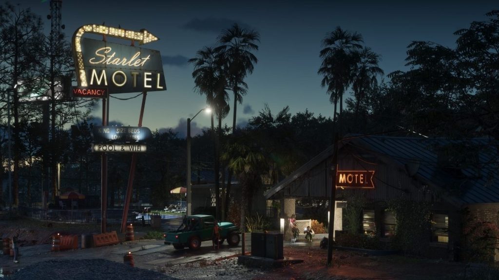 Gece vaktinde ışıklı büyük bir Starlet Motel tabelasının altında duran yeşil arazi aracı ve palmiye ağaçları